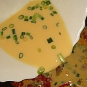 1. Этап. Омлет в мультиварке: К этому времени колбаса и помидоры должны быть обжарены. В яйца добавьте зеленый лук и вылейте смесь в чашу мультиварки.