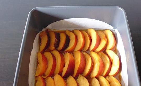1. Этап. Пирог с персиками и карамелью: Персики помойте, нарежьте тонкими дольками и аккуратно выложите на карамель.