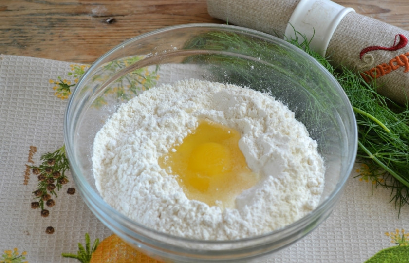 1. Этап. Чебуреки с мясом: Для теста смешайте половину муки, соль и сахар, хорошо перемешайте сухую смесь. Затем сделайте в середине небольшое углубление, туда же вбейте 1 яйцо и влейте воду. Хорошенько размешайте до однородного состояния.