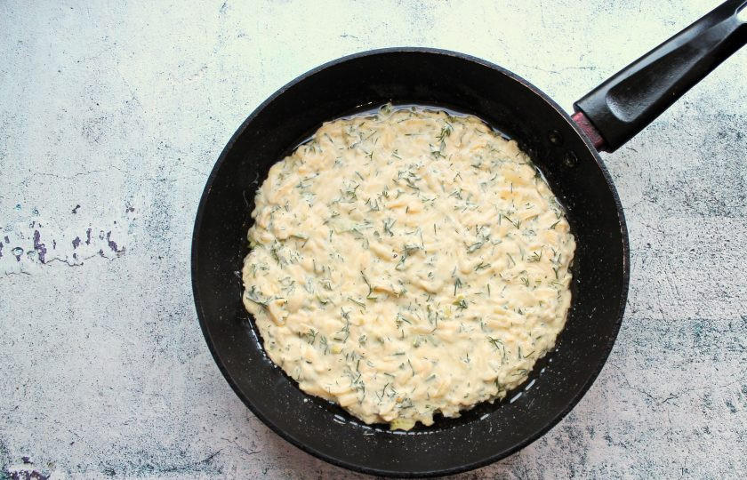 1. Этап. Хачапури ленивые с сыром и зеленью: В сковороду налейте растительное масло и разогрейте на среднем огне. Переложите тесто в сковороду и разровняйте.