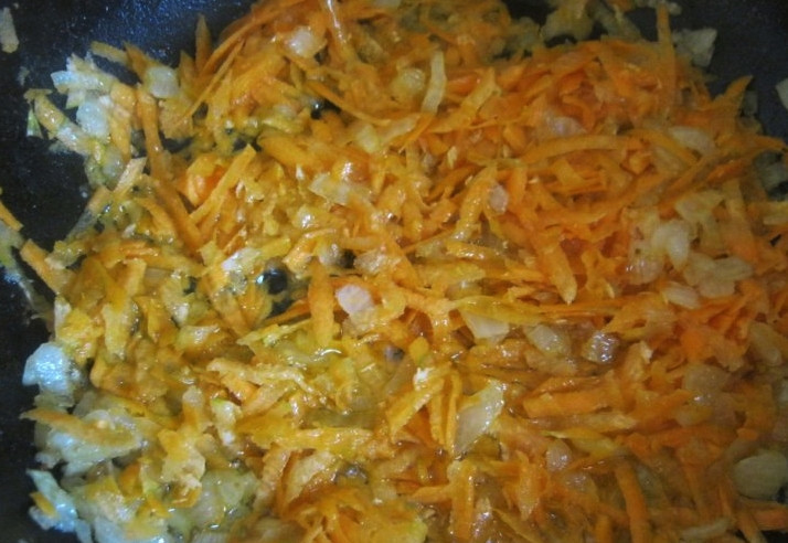 1. Этап. Гречка с грибами: Репчатый лук очистите и нарежьте небольшими кусочками. Морковь тоже очистите и натрите на крупной тёрке либо очень мелко нашинкуйте. На сковороде разогрейте растительное масло и обжарьте морковь с луком до мягкости и золотистого цвета. Затем туда же отправьте промытые и некрупно нарезанные шампиньоны. Накройте сковороду и тушите содержимое на слабом огне.