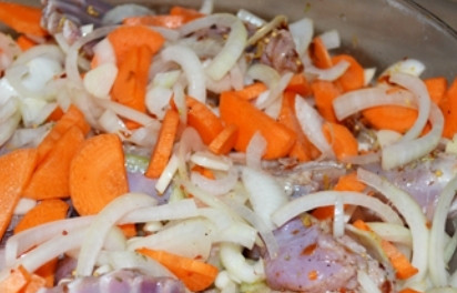 1. Этап. Кролик, тушенный в вине с овощами: Добавляем нарезанные морковь и лук. Еще раз перемешиваем и ставим в холодильник на пару часов мариноваться.