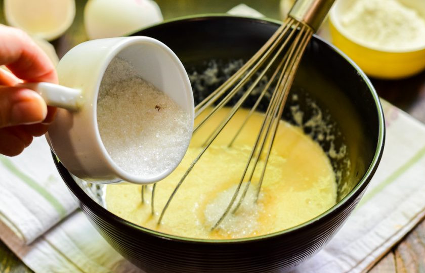 1. Этап. Оладьи на кефире без масла: Добавьте сахарный песок в основу. По желанию можете использовать заменитель сахара или ванильный сахар, для более яркого аромата.