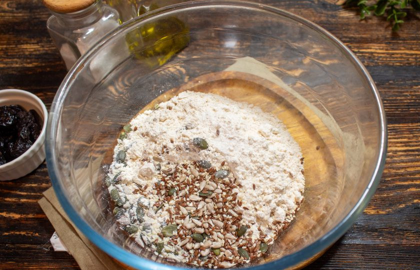 1. Этап. Хлеб с черносливом: В глубокую миску всыпьте просеянную муку, добавьте соль и семечки.