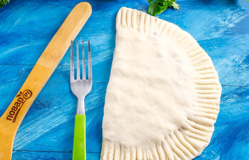 1. Этап. Чебуреки в казане: Смочите края теста водой и слепите их вместе. Обмакните вилку в муку и сделайте узоры на краях заготовок.