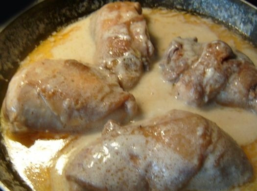 1. Этап. Куриные бедра, тушеные в сметане: 7. Выложить бедра на сковороду к соусу, снова довести до кипения и накрыть крышкой, убрав огонь до минимума. Куриные бедра, тушеные в сметане в домашних условиях будут готовы через 45-60 минут, в зависимости от их размера. При желании за 5 минут до подачи к столу можно добавить в соус немного тертого сыра и измельченную свежую зелень.