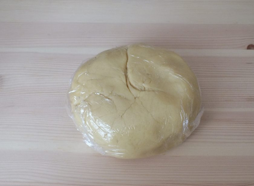 1. Этап. Песочники: К полученной маслянистой массе добавьте часть муки, соль, разрыхлитель и зашивайте тесто ложкой. Всыпьте еще муку и быстро замешивайте руками. Как только тесто собралось в комок, больше не месите. Оберните тесто в пищевую пленку и уберите на 40 минут в холодильник.