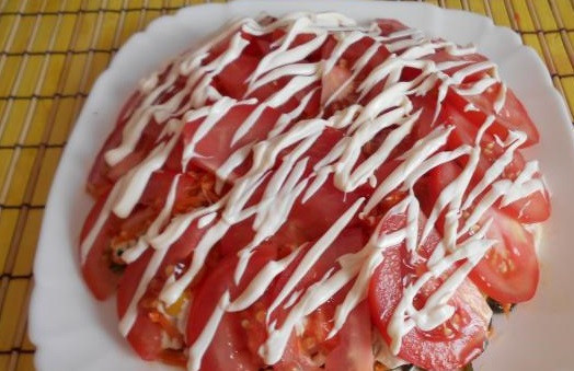 1. Этап. Салат из морской капусты с морковью: 11. Помидоры нарежьте в виде тонких слайсов. Уложите их сверху, полностью накрывая все ингредиенты. Сверху – тонкая сетка из майонеза.