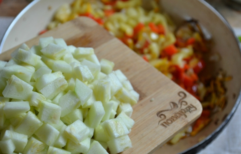 1. Этап. Икра кабачковая с перцем и помидорами: В сковороде разогрейте подсолнечное масло. Сначала высыпьте лук и поджарьте 2 минуты на среднем огне. Потом добавьте тертую морковь и порезанный перец. Пассеруйте 5 минут. Далее добавьте кабачок, слегка отжав его от образовавшегося сока. Хорошо перемешайте, накройте крышкой и тушите на медленном огне 10 минут.