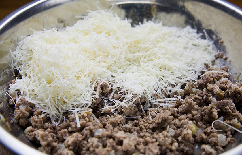 1. Этап. Картофельный рулет с мясом: Фарш обжариваем с порубленным луком на сковородке около 20 минут. Солим, всыпаем к мясной начинке тертый пармезан.