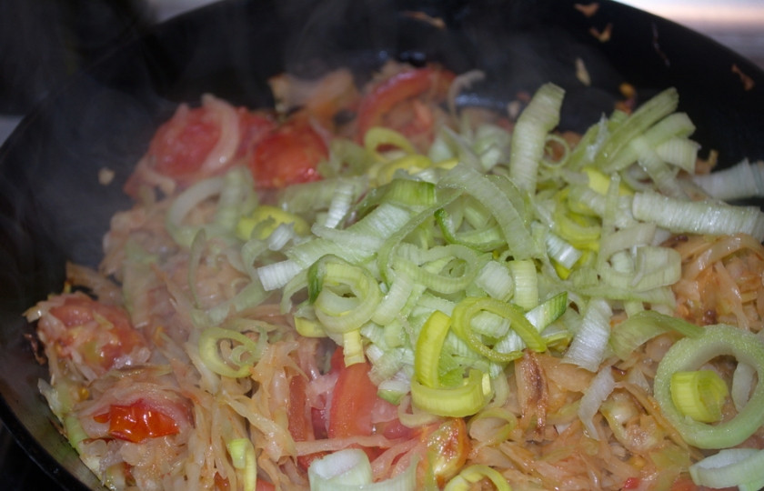 1. Этап. Пирог с капустой и овощами: Добавьте лук порей. Перемешайте. Тушите все вместе еще 3 минуты.