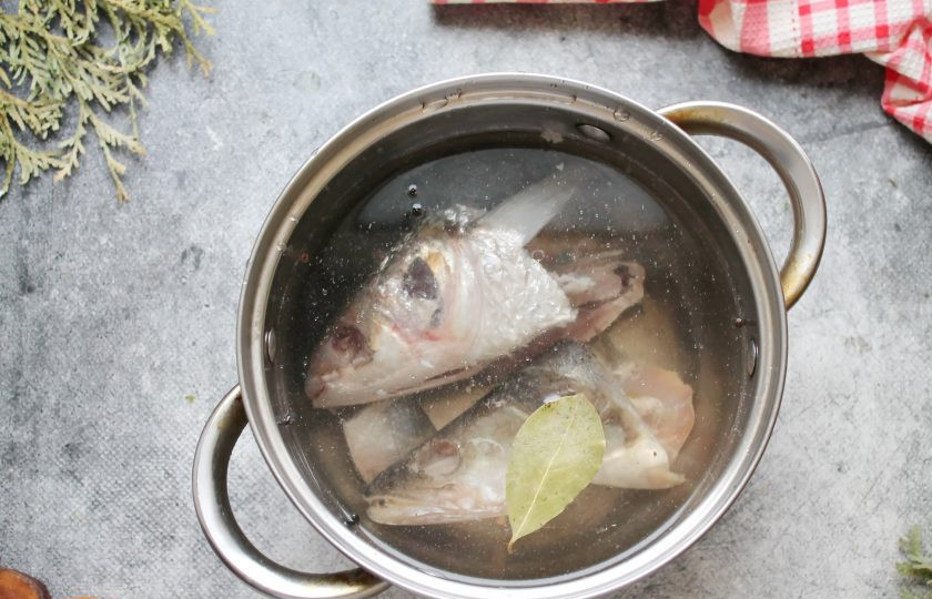 1. Этап. Уха из рыбных голов: В кастрюлю выложите рыбные головы, влейте холодную воду, добавьте лавровый лист, перец горошком, немного посолите и поставьте на средний огонь. Доведите все до кипения, удалите пену и варите на медленном огне в течение 30 минут.