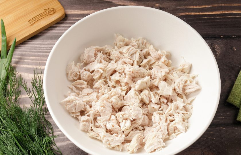 1. Этап. Салат с курицей, грибами и маринованными огурцами: Отварное филе нарежьте кубиками.
