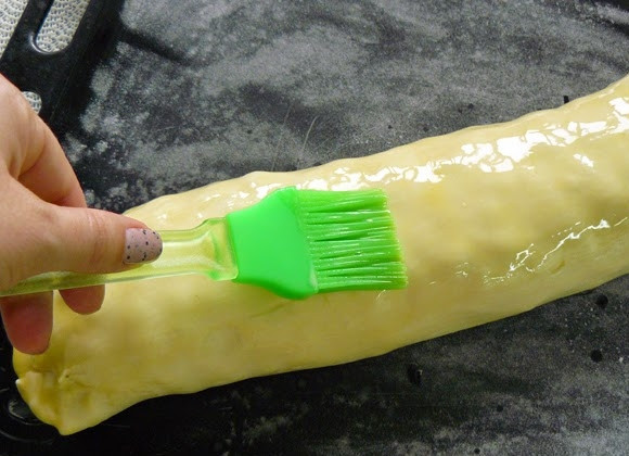 1. Этап. Яблочный штрудель из готового слоеного теста: Выложите штрудель на противень (местом скрепления вниз). Растопите оставшееся сливочное масло, смажьте им штрудель. Отправьте в духовку минут на 25-30. Пускай запекается до румяного цвета. Можете еще смазать сливочным маслом в процессе выпекания.