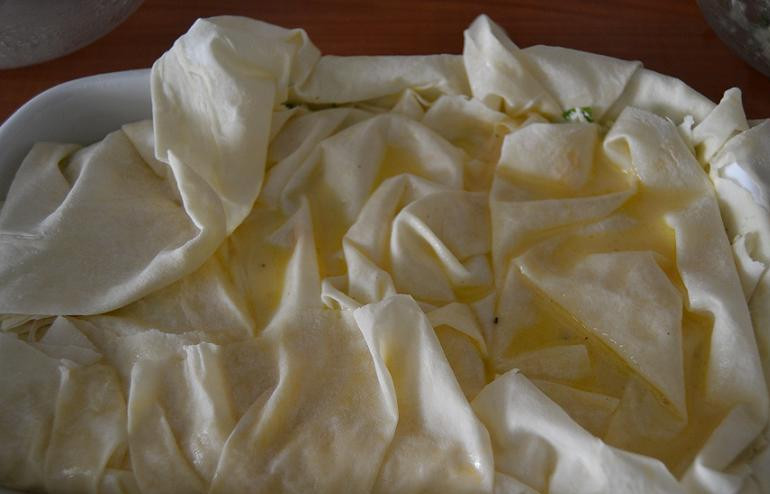 1. Этап. Берек с сыром: Накрываем все вторым пластом теста, опять собираем его складками. Поливаем второй слой заливкой и посыпаем оставшейся начинкой. И выкладываем третий пласт из теста.