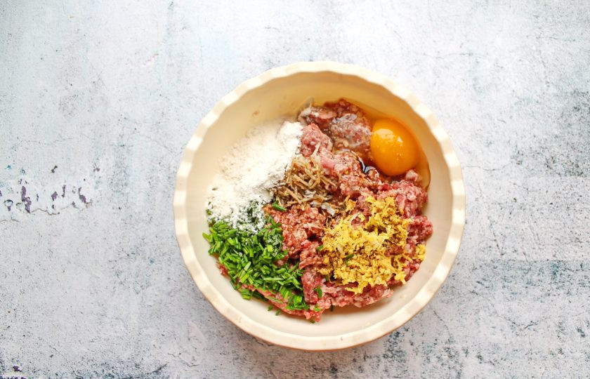 1. Этап. Тефтели Львиные головы: Влейте в фарш соевый соус, кунжутное масло, вино и всыпьте муку.