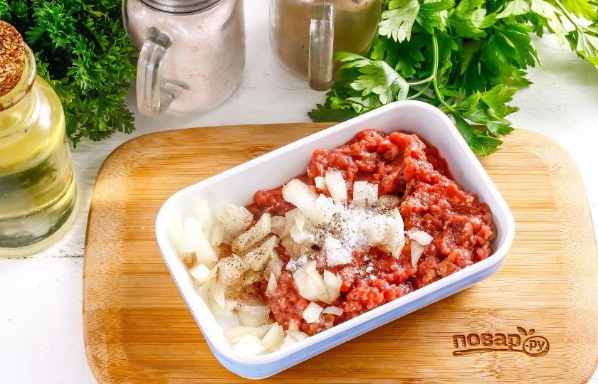 1. Этап. Чебуреки в казане: В это время в говяжий фарш нарежьте репчатый лук мелким кубиком, всыпьте соль и молотый черный перец. Тщательно все перемешайте.