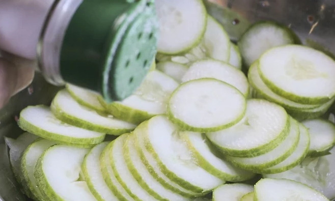 1. Этап. Салат с растительным маслом: Огурчики моем и режем очень тонкими кружочками. Присыпьте солью, перемешайте и поместите в дуршлаг.