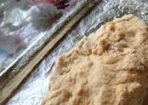 1. Этап. Печенье на кефире и маргарине: От теста отделяем небольшую часть (примерно 1/6), заворачиваем в пленку и убираем в морозильник. Оставшуюся часть делим на 2 части, каждую раскладываем на противень, смазанный маслом, и равномерно там распределяем.