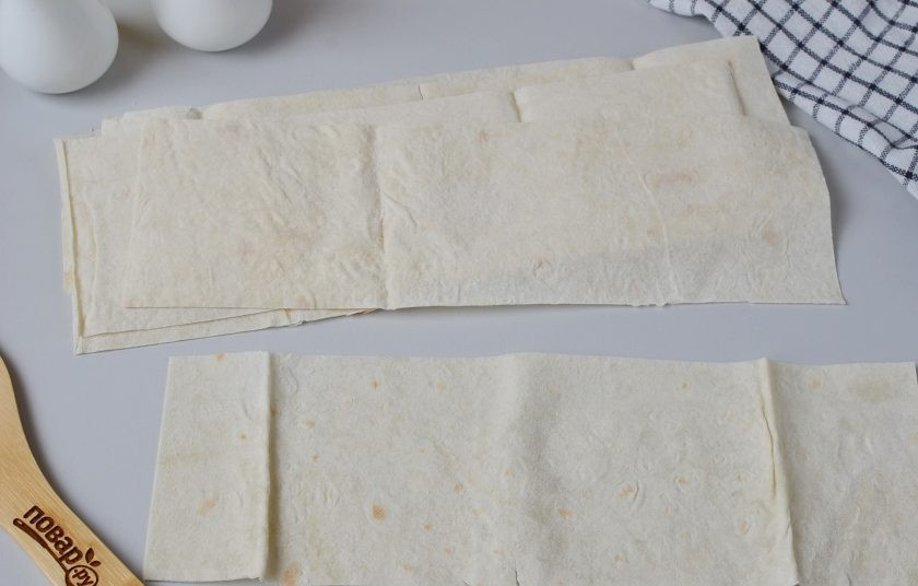 1. Этап. Пирожки в лаваше: Порежьте лаваши на полоски 9 на 28 см. Соотношение ширины к длине 1:3 (не меньше), поскольку, чтобы треугольник получился закрытым со всех сторон нужно минимум 4 заворота.