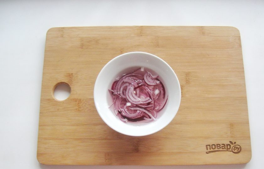 1. Этап. Салат Купеческий на Новый год: Репчатый лук очистите, помойте, нарежьте полукольцами и выложите в мисочку. Залейте водой, уксусом и добавьте сахар. Дайте постоять 10-15 минут, после маринад слейте.
