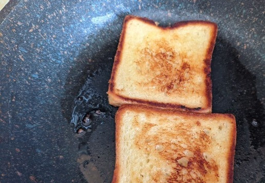 1. Этап. Техасские тосты с индейкой и яичницей: Далее разогреваем чистую сковороду. Кладём 2 ст. л. сливочного масла и растапливаем его. Кладём тостовый хлеб в сковороду и поджариваем его до золотисто-коричневой корочки 2-3 минуты. Переворачиваем и жарим с другой стороны до золотисто-коричневой корочки, ещё 2-3 минуты, при необходимости добавляя больше сливочного масла. Убираем хлеб со сковороды.