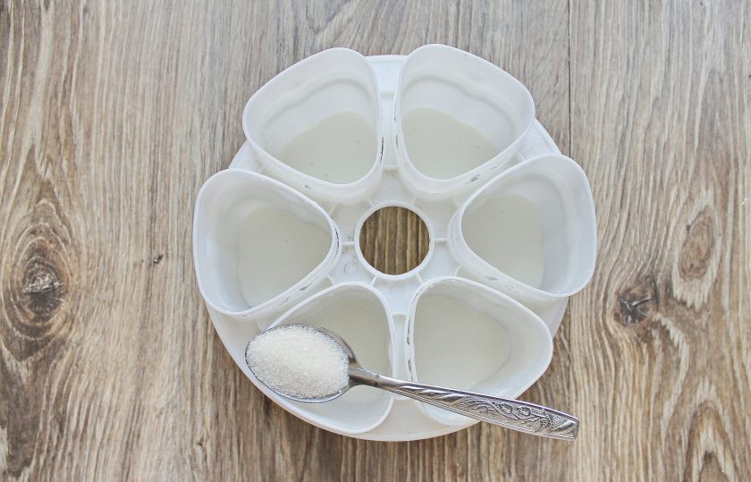 1. Этап. Йогурт в мультиварке на кефире: Всыпьте по одной чайной ложке сахара в каждую.