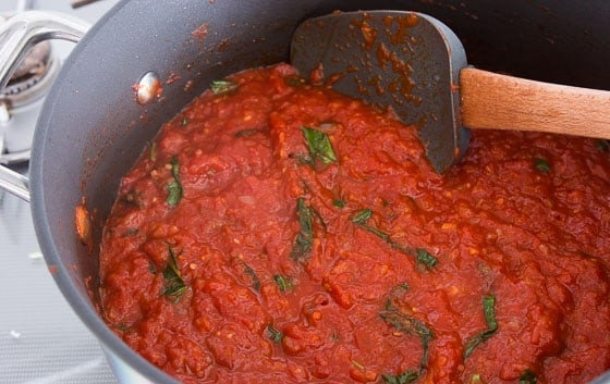1. Этап. Классический томатный соус: 2. Добавьте в сотейник консервированные томаты (если используете свежие, очистите их от кожуры), томатную пасту, соль, черный молотый перец, листья базилика. Варите соус около 10-15 минут, если хотите густую консистенцию, то увеличьте время.