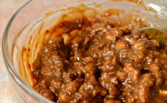 1. Этап. Торт Сникерс с крекером: 8. Соедините орешки, кусочки крекера и вареную сгущенку. Все тщательно перемешайте.