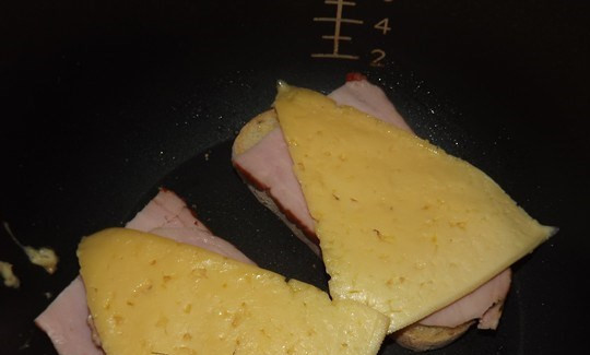 1. Этап. Бутерброды в мультиварке: Намазываем хлеб сливочным маслом, кладем на него ветчину и кусочек сыра. Перекладываем бутерброд в мультиварку и готовим в режиме 