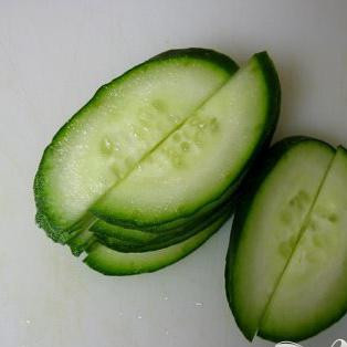 1. Этап. Пряный салат из огурцов: Порежьте поперёк и затем пополам. И положите в солёную воду на 20 минут.