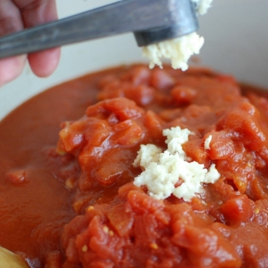 1. Этап. Густой итальянский томатный суп с макаронами и фаршем: Сразу вслед за этим добавляем в кастрюлю томатную пасту и помидоры в собственном соку. При желании, можно добавить немножко томатного сока. Туда же добавляем измельченный чеснок.