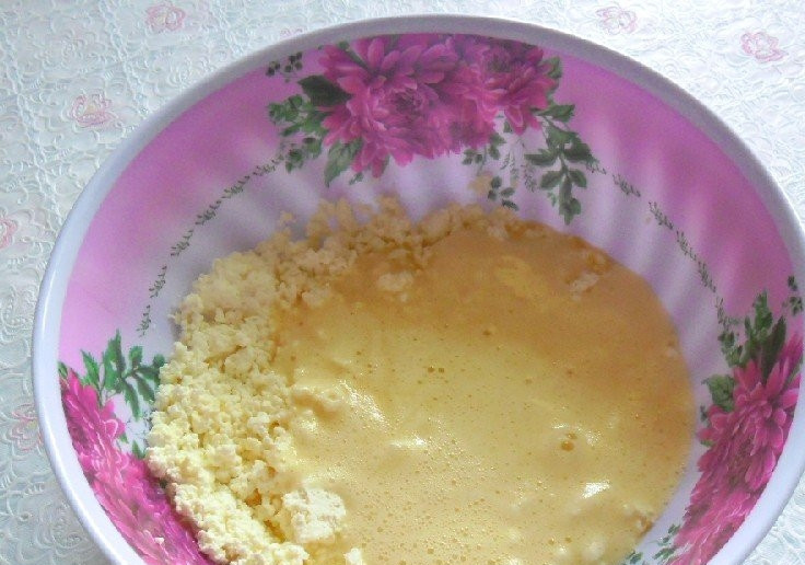 1. Этап. Пышные оладьи с творогом: В отдельную миску выложите творог и хорошо разотрите его вилкой. Затем отправьте туда стакан кефира. Всё хорошо перемешайте, чтобы в твороге не оставалось крупных комочков.