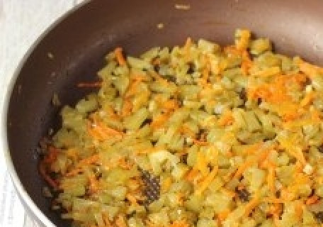 1. Этап. Рассольник из свинины: Добавляем нарезанные огурцы в сковороду к луку и моркови. Перемешиваем и обжариваем ещё несколько минут. Готовую зажарку снимаем с плиты.