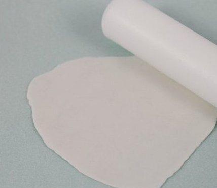 1. Этап. Сахарные цветы: Рабочую поверхность присыпьте кукурузным крахмалом и разомните белую мастику, чтобы она стала мягкой. При необходимости досыпьте еще крахмал и раскатайте мастику в пласт толщиной 1 мм. Пласт не должен прилипать к рабочей поверхности.