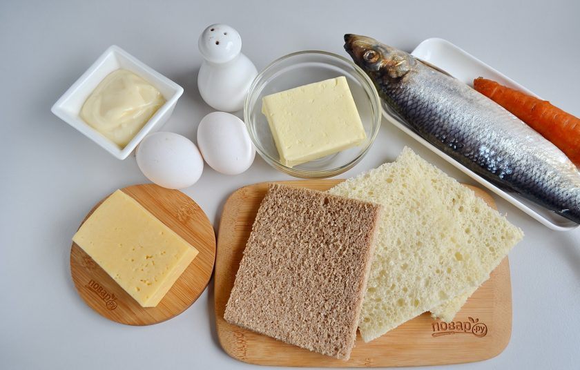 1. Этап. Закусочный бутербродный торт с рыбой: Итак, отварите морковь и яйца. Если яйцо крупное, то достаточно одного, если среднее, то отварите лучше два. Селедочку филетируйте, если селедка крупная, то понадобится лишь одно филе. Ломтики хлеба у меня размером как половинка хлеба, я взяла половинку 