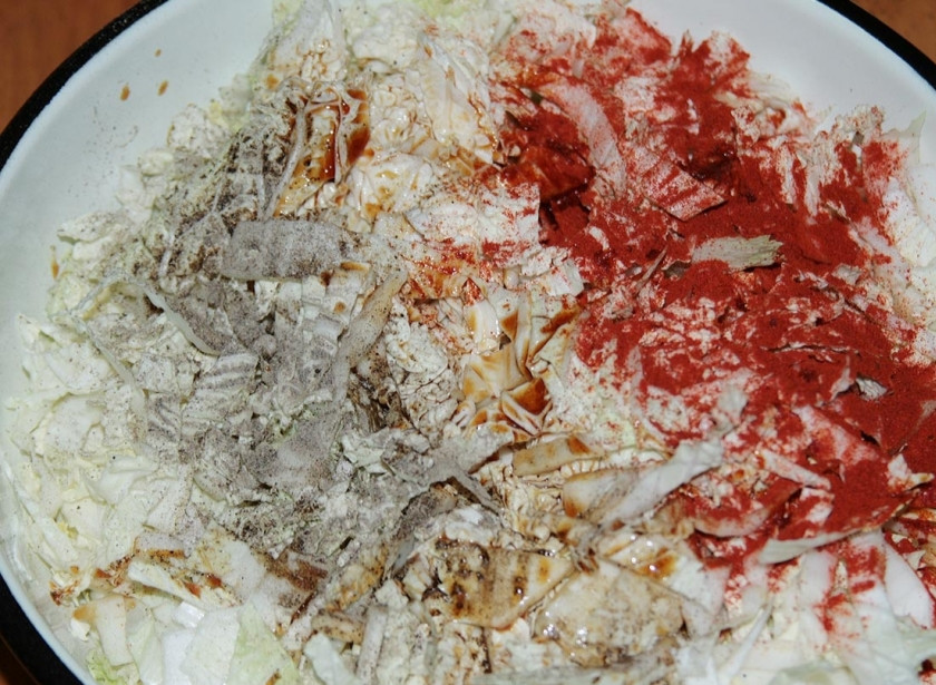 1. Этап. Салат пикантный с колбасой: Добавьте в капусту щепотку соли, паприку и черный перец, а также соевый соус. Перемешайте все руками, оставьте на минут 15, чтобы капуста дала сок.