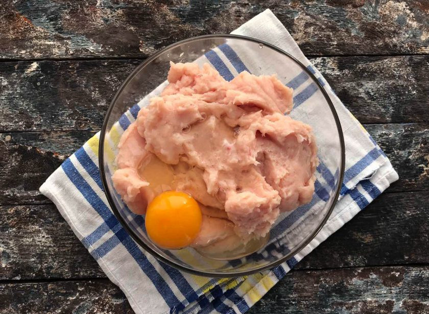 1. Этап. Домашние сосиски с сыром: Выложите подготовленный фарш в глубокую тарелку и добавьте к нему яйцо.