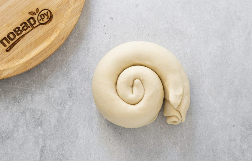 1. Этап. Лепешки на воде с луком: Сверните пласт в рулет с широкой стороны, затем закрутите в улитку.