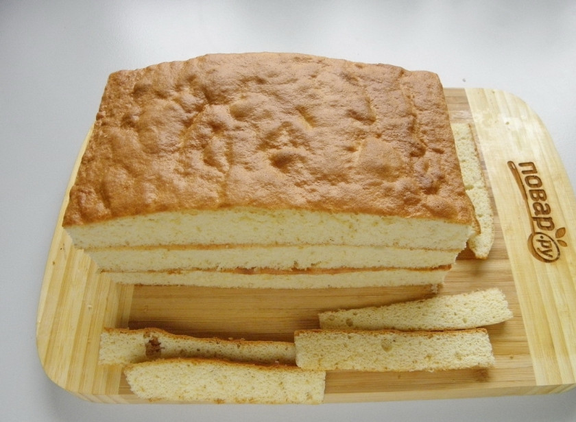 1. Этап. Ленивый медовик: Бисквит освободите от бумаги. Порежьте на три равных части. Обрежьте края.