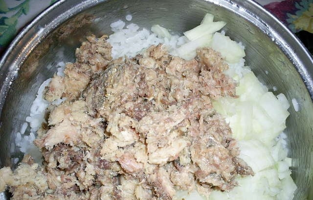 1. Этап. Котлеты из консервов с рисом: 4. Далее смешиваем рыбу, готовый рис и лук. Вбиваем яйцо, солим и перчим по вкусу. Можно также добавить приправу для рыбы или какие-либо другие специи на собственное усмотрение. Хорошенько перемешиваем все ингредиенты до получения однородной массы.