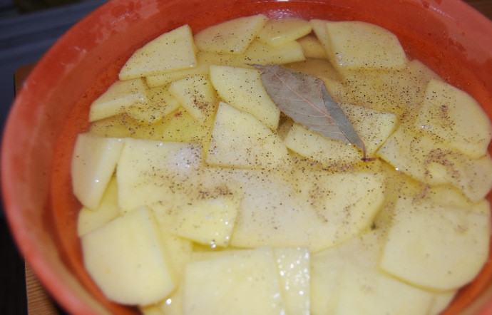 1. Этап. Конина в духовке: Сверху выложите картошку ломтиками, добавьте специи по вкусу и лавровый лист, залейте бульоном или водой (не горячей, а теплой) так, чтобы та лишь слегка покрывала картошку.