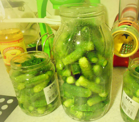 1. Этап. Огурчики с кетчупом чили: 1. Огурцы тщательно помоем и замочим в холодной воде на 4-6 часов. Тем временем стерилизуем банки, выкладываем на дно каждой зелень. Огурцы обрезаем с двух сторон, плотно утрамбовываем в банки.