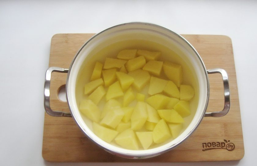 1. Этап. Шурпа из тушенки: Картошку очистите, помойте, нарежьте и выложите в кастрюлю. Залейте водой и поставьте на плиту.