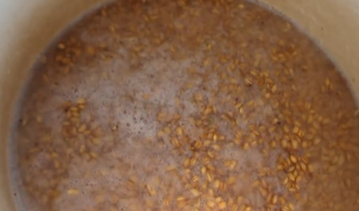 1. Этап. Брага на пшенице без дрожжей: Уже через 3-4 дня пшеница начнет бродить и пениться. Засыпьте оставшийся сахар и влейте еще 6 литров воды. Установите гидрозатвор и периодически помешивайте смесь.