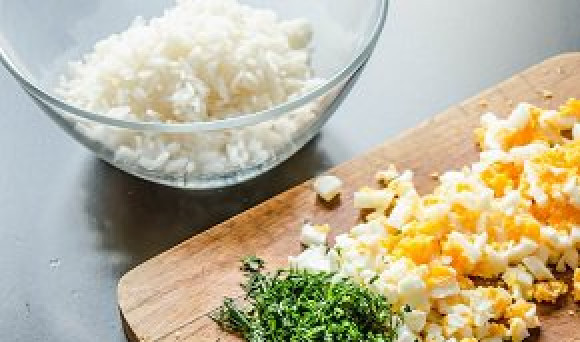 1. Этап. Курник из слоеного теста: Отваренное вкрутую яйцо разрезаем на мелкие кусочки. Смешиваем рис, яйцо, укроп (порубленный), заливаем растопленное сливочное масло, добавляем соль и перец по вкусу.