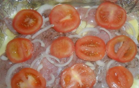 1. Этап. Мясо индейки в духовке: На мясо с луком выложите тонко нарезанные помидоры.