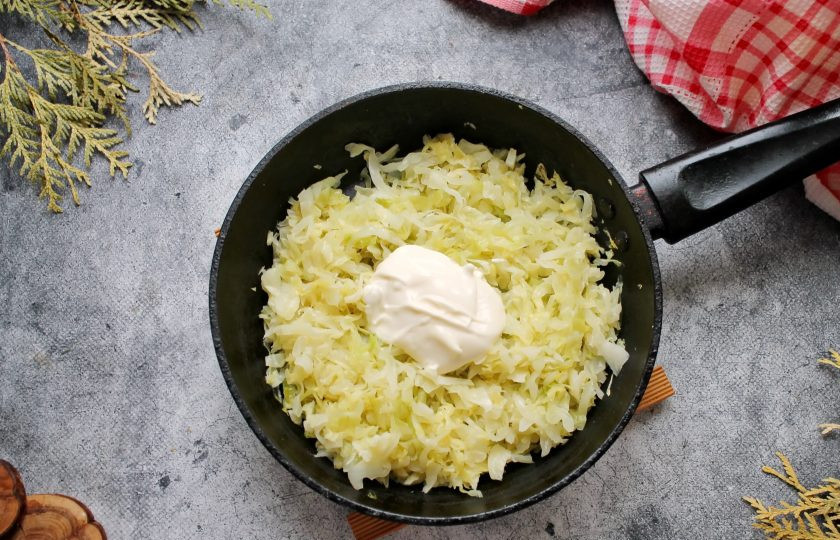 1. Этап. Капустники: Добавьте к капусте сметану, перемешайте и готовьте еще 2 минуты, перемешивая. Снимите с огня и полностью остудите.