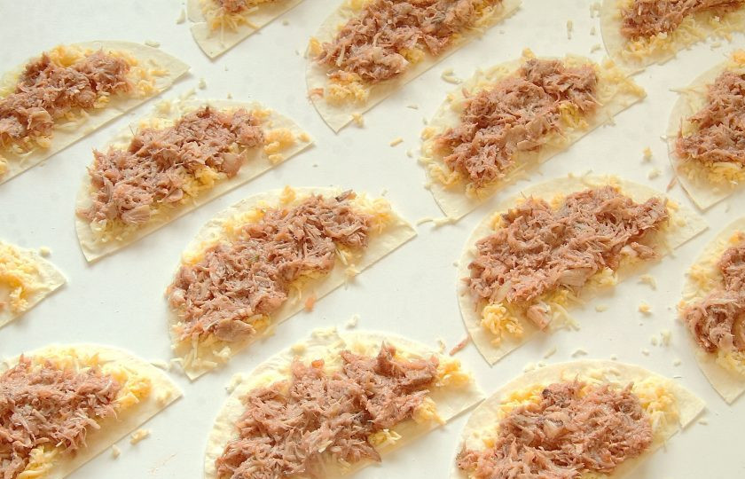 1. Этап. Закуска Цветущее кольцо Кесадильи: Разложите заготовки для кесадильи и распределите на них тертый сыр и куриную начинку.