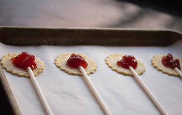 1. Этап. Мини-пирожки на палочке: 3. Выложить 1/2-1 чайную ложку варенья на середину каждого кружка и выложить палочки для леденцов в центре.